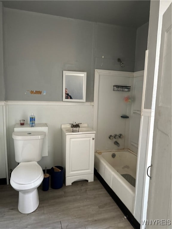 bathroom with a shower, toilet, sink, and hardwood / wood-style flooring