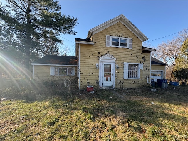 rear view of property featuring a lawn