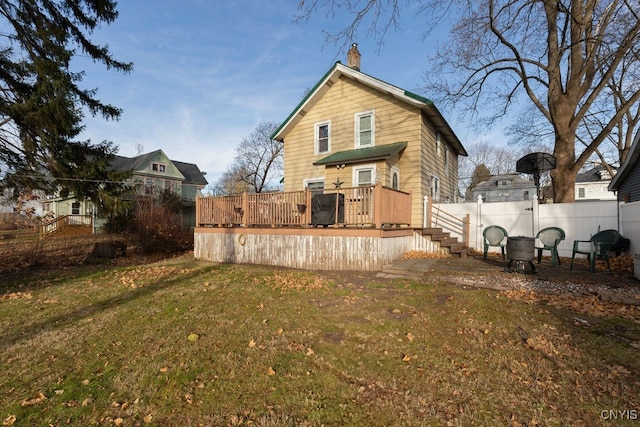 rear view of property featuring a yard and a deck