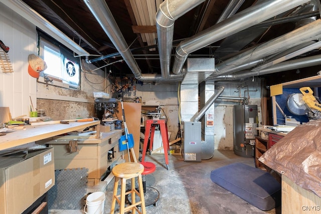 basement with a workshop area, heating unit, and water heater