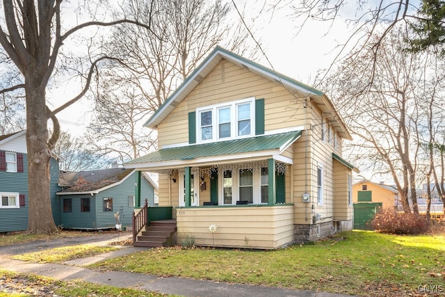 bungalow-style home featuring a front yard and covered porch