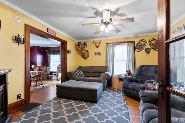 living room with plenty of natural light, wood-type flooring, and ornamental molding