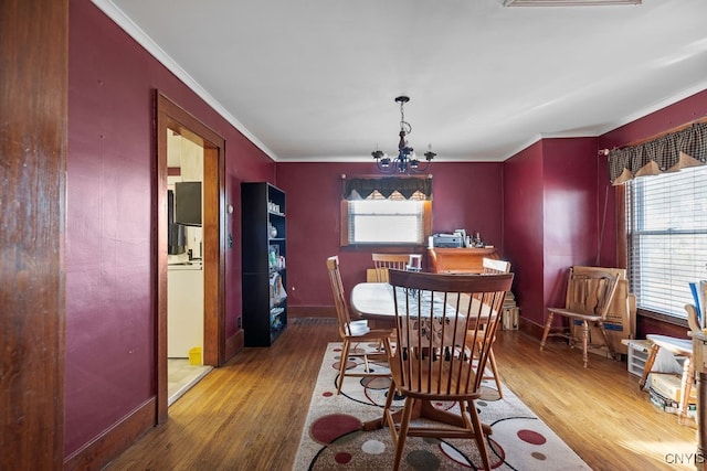 dining room featuring hardwood / wood-style flooring, crown molding, and a chandelier