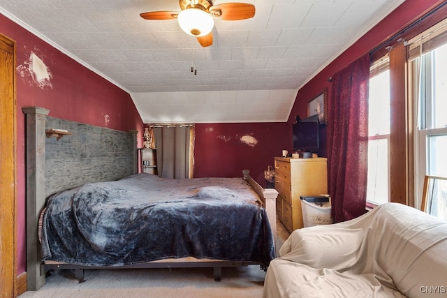 carpeted bedroom featuring ceiling fan, lofted ceiling, and ornamental molding