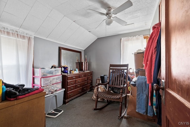 bedroom with ceiling fan, lofted ceiling, and dark colored carpet