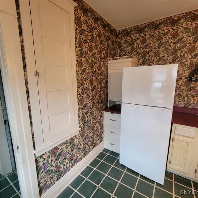 kitchen with white fridge and white cabinetry