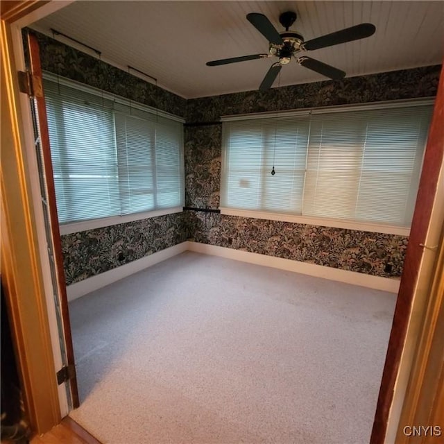 carpeted spare room featuring ceiling fan