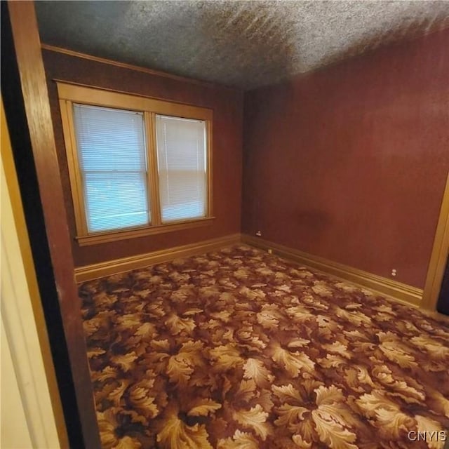 unfurnished room featuring a textured ceiling