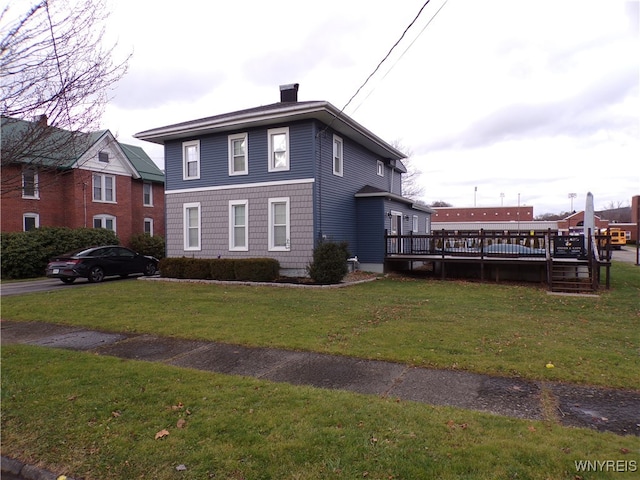 view of front facade featuring a wooden deck and a front yard