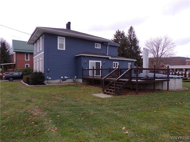 rear view of house featuring a pool side deck and a lawn