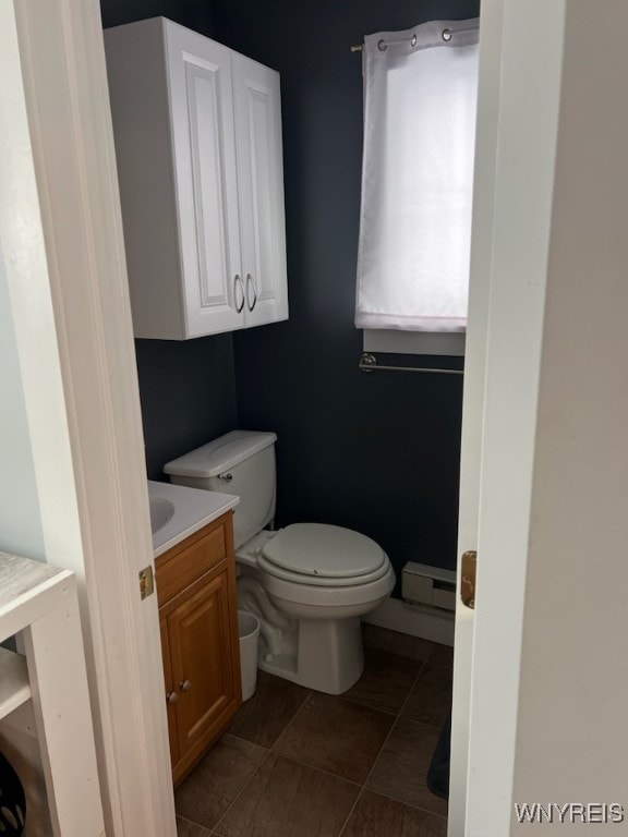 bathroom featuring tile patterned floors, vanity, a baseboard heating unit, and toilet