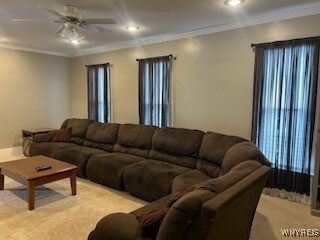 living room featuring light carpet, ceiling fan, and ornamental molding