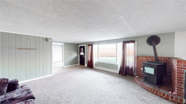 living room featuring wood walls, a wood stove, a textured ceiling, and light carpet