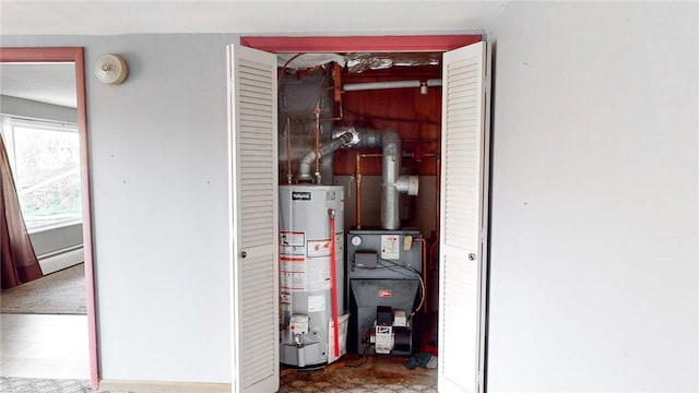 utility room with a baseboard radiator and water heater