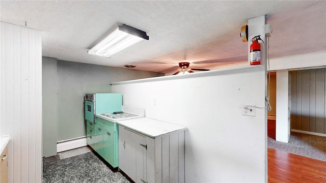 clothes washing area featuring baseboard heating, ceiling fan, dark hardwood / wood-style floors, and a textured ceiling