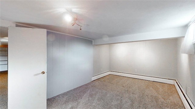 basement featuring carpet floors, baseboard heating, and wood walls