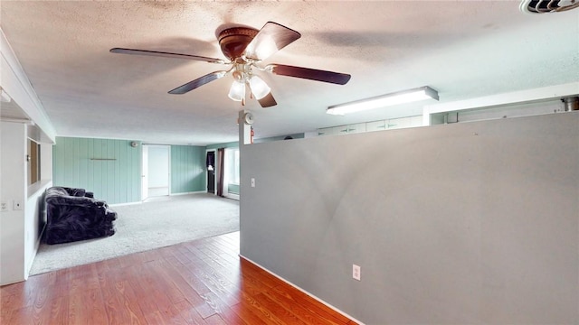 interior space with ceiling fan, a textured ceiling, and hardwood / wood-style flooring