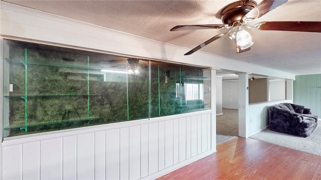 interior space featuring wood walls, plenty of natural light, a textured ceiling, and hardwood / wood-style flooring