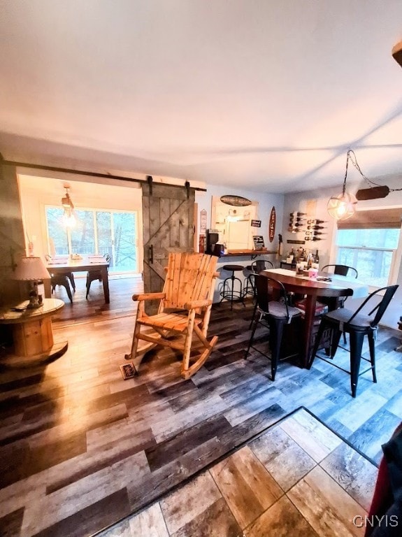 dining room with a barn door and hardwood / wood-style flooring