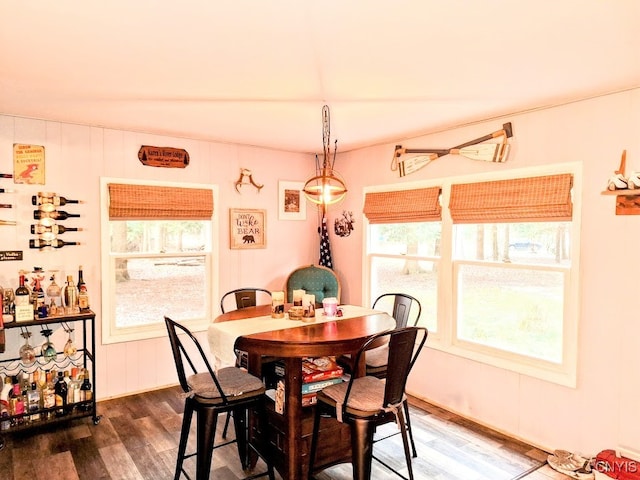 dining room with hardwood / wood-style floors, a wealth of natural light, and vaulted ceiling