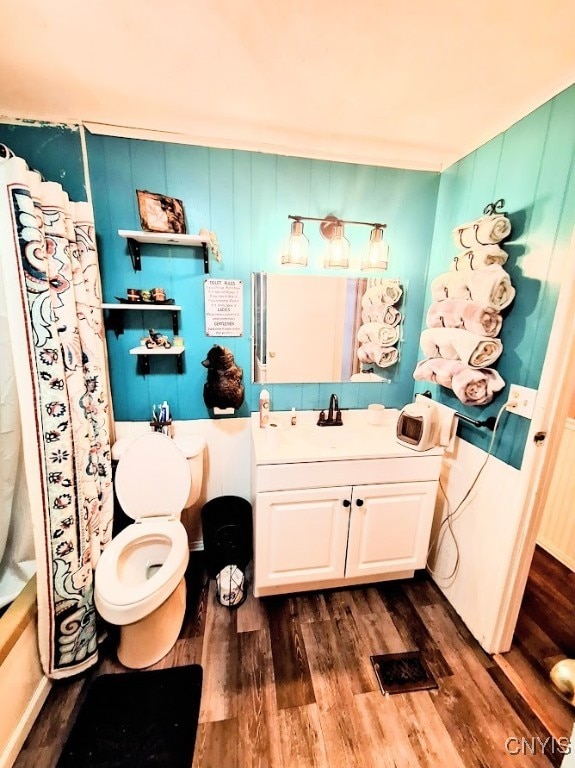 full bathroom with shower / bath combination with curtain, vanity, wood-type flooring, and toilet