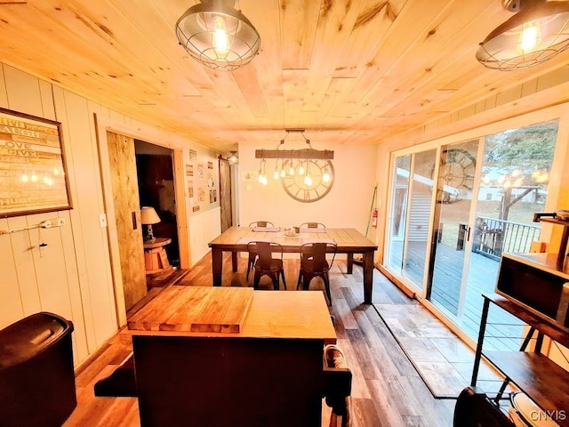 dining area featuring wood walls, light wood-type flooring, and wood ceiling