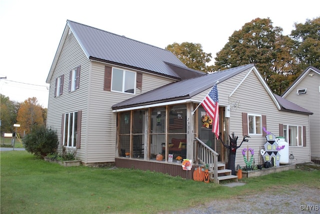 rear view of property featuring a lawn and a sunroom