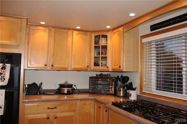 kitchen featuring light brown cabinets and black appliances