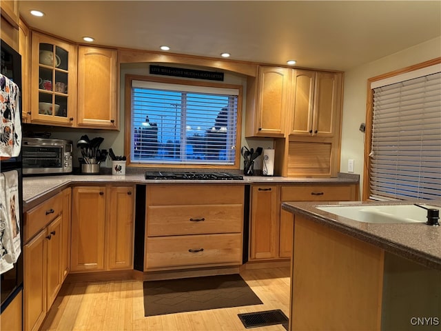 kitchen with sink, light hardwood / wood-style flooring, and stainless steel gas stovetop