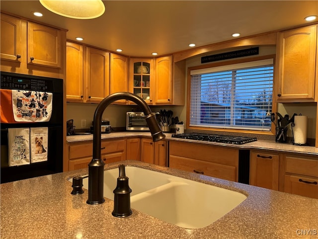 kitchen featuring black fridge, sink, and stainless steel gas cooktop