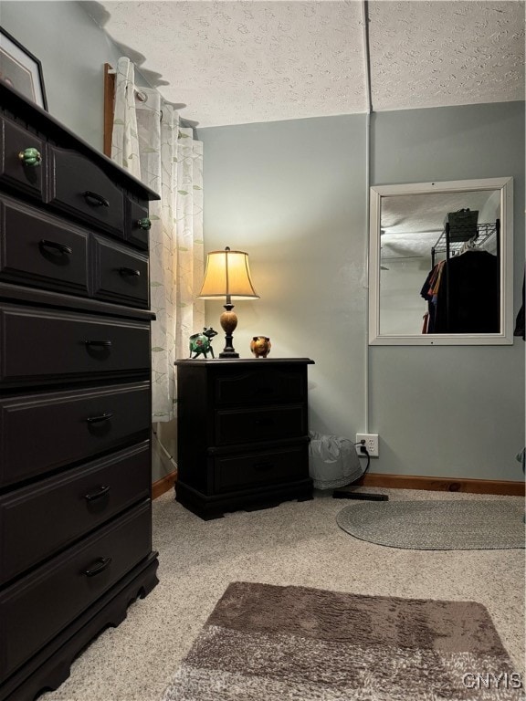 bedroom with light colored carpet and a textured ceiling