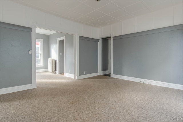 carpeted spare room featuring radiator heating unit