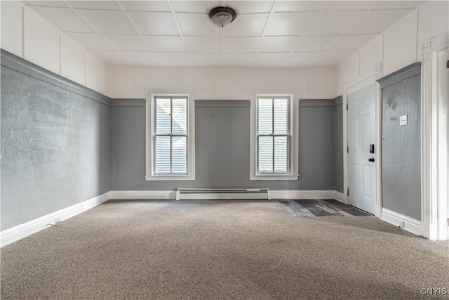 unfurnished room with a paneled ceiling, carpet floors, and a baseboard radiator