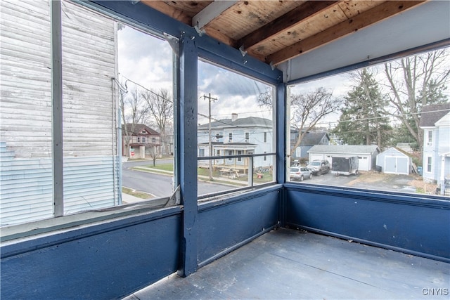 unfurnished sunroom with beam ceiling and plenty of natural light