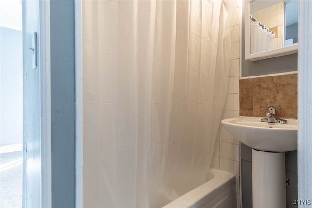 bathroom featuring shower / tub combo with curtain and tile walls