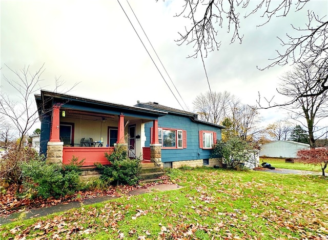 bungalow-style home with covered porch and a front lawn