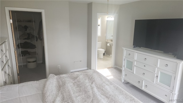 carpeted bedroom featuring connected bathroom, a spacious closet, and a closet