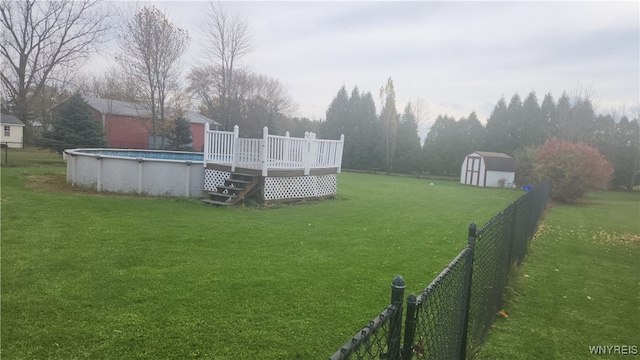 view of yard with a storage shed and a pool side deck