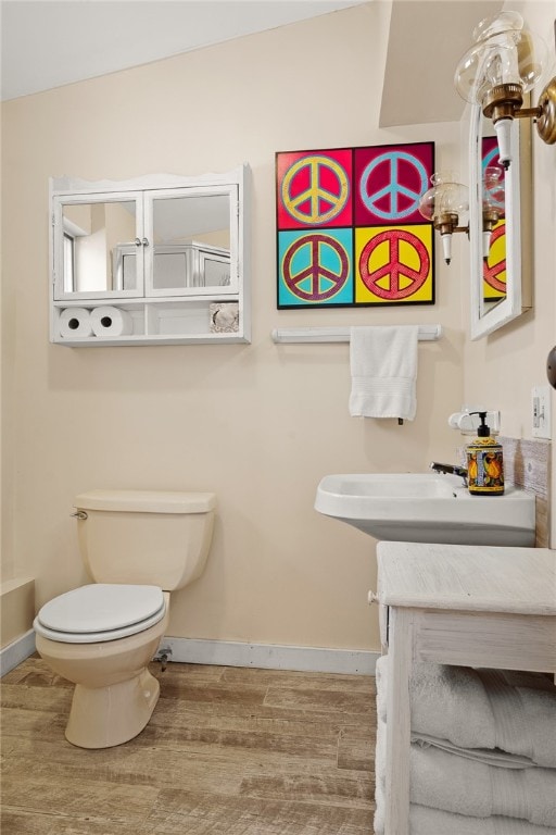 bathroom featuring sink, toilet, and hardwood / wood-style flooring