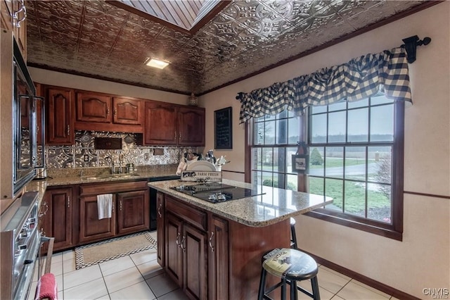 kitchen with oven, sink, decorative backsplash, light stone countertops, and black electric cooktop