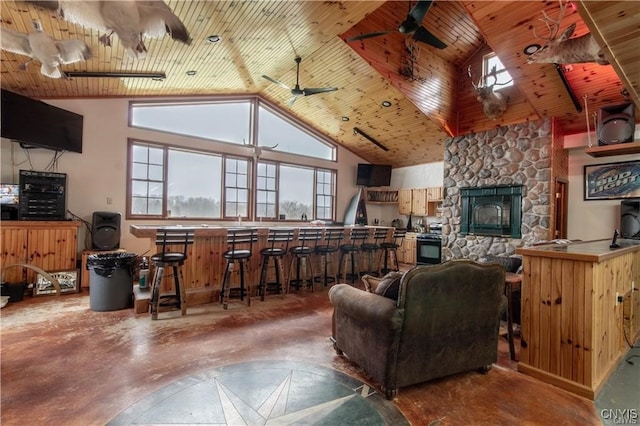 living room featuring a stone fireplace, wooden ceiling, and lofted ceiling