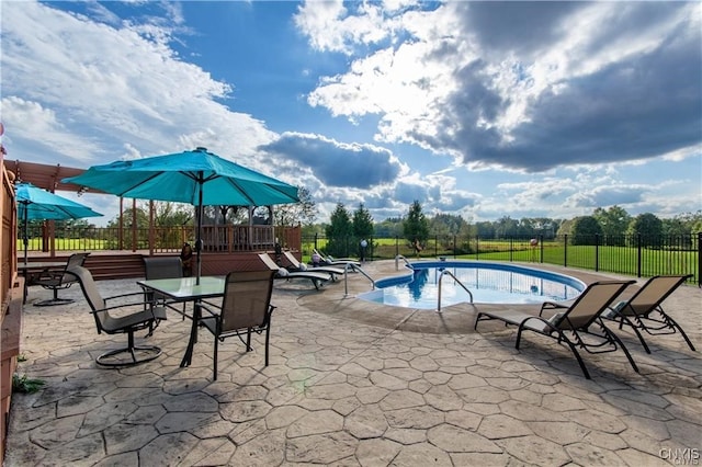 view of pool featuring a patio area and a wooden deck