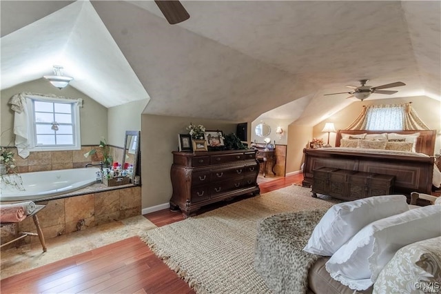 bedroom with ceiling fan, light hardwood / wood-style floors, and lofted ceiling