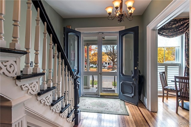 entrance foyer with hardwood / wood-style floors and a chandelier