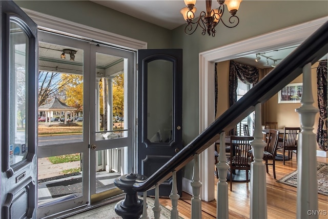 interior space with hardwood / wood-style floors, french doors, and an inviting chandelier