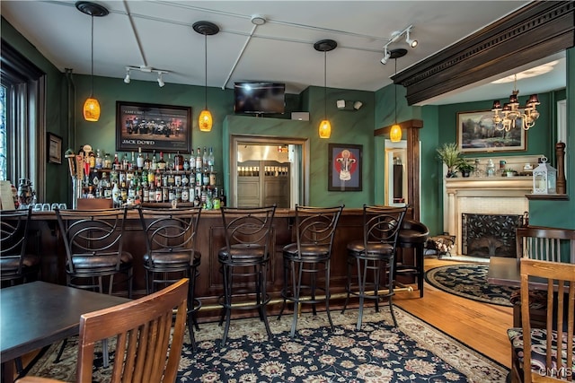 bar with pendant lighting, track lighting, and hardwood / wood-style flooring