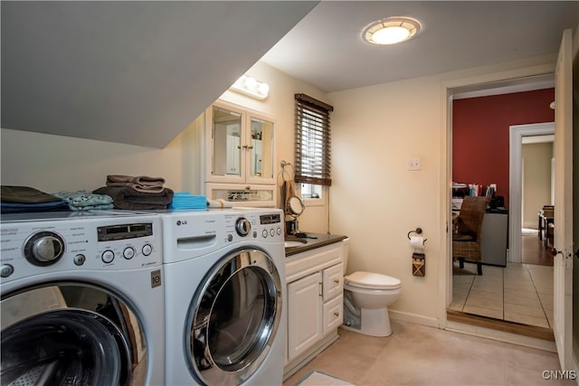 laundry room with washing machine and clothes dryer and light tile patterned floors