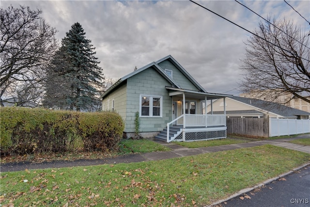 view of front of home featuring covered porch and a front yard