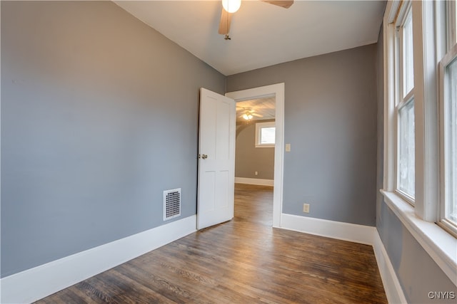 empty room with ceiling fan and dark wood-type flooring