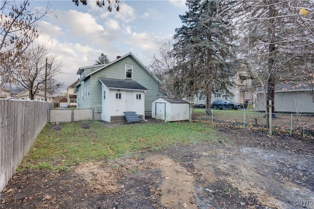 back of house featuring a storage unit